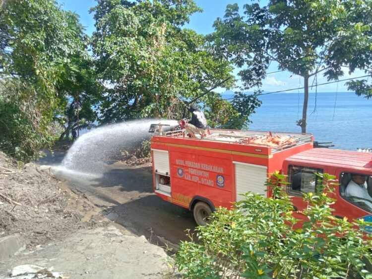 Dinas SatPol PP-Damkar Sitaro Kerahkan Mobil Pemadam untuk Siram Jalan di Bekas Lokasi Longsor